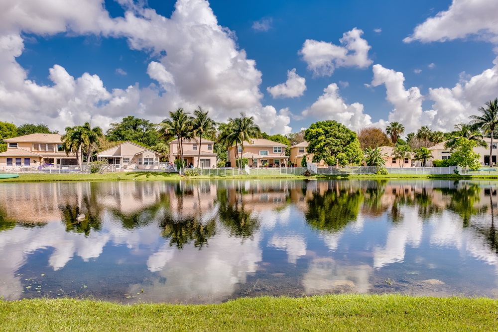 A row of lakeside homes in Coconut Creek, Florida on a sunny day.