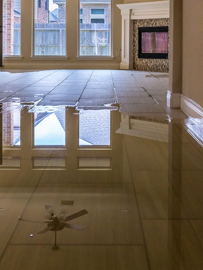 A tile floor is covered with water inside a home.